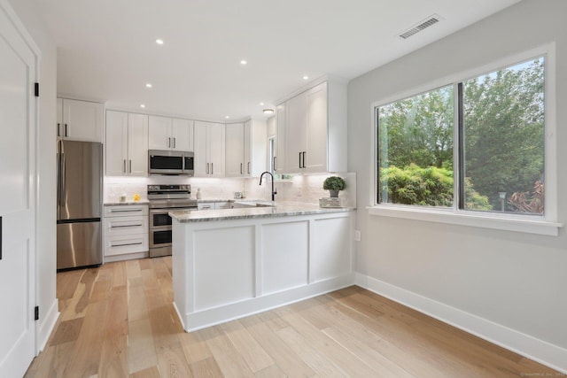 787 Heritage Vlg Unit A, Southbury, CT 06488 - kitchen featuring stainless steel appliances, tasteful backsplash, a peninsula, white cabinetry, and recessed lighting