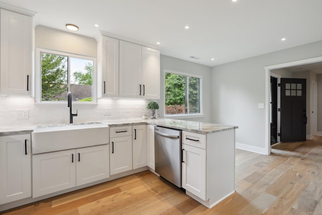 787 Heritage Vlg Unit A, Southbury, CT 06488 - kitchen with stainless steel dishwasher, a sink, a peninsula, decorative backsplash, and light wood-type flooring