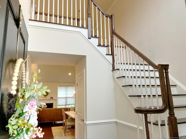 17 Highridge Rd Unit 17, Middlebury, CT 06762 - staircase featuring a towering ceiling, a fireplace, and wood finished floors
