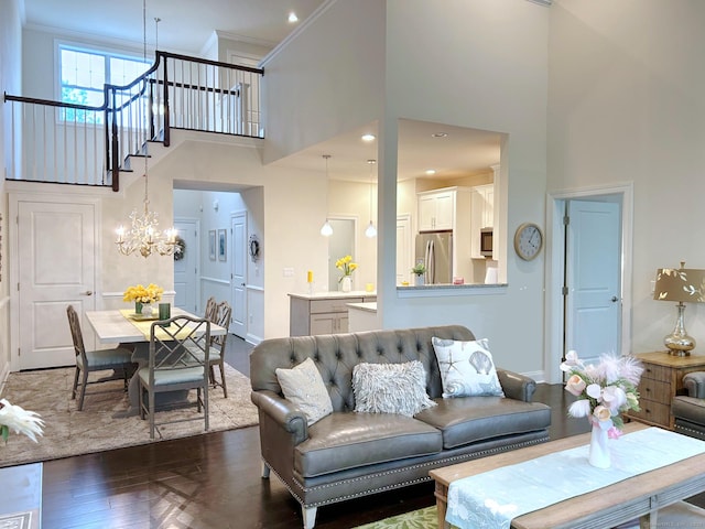 17 Highridge Rd Unit 17, Middlebury, CT 06762 - living area featuring a towering ceiling, a chandelier, dark wood-style floors, crown molding, and baseboards