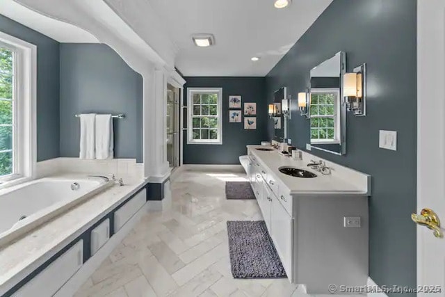 122 Mirey Dam Rd, Middlebury, CT 06762 - bathroom featuring a bath, double vanity, recessed lighting, and marble look tile flooring