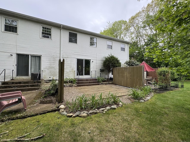 back of property featuring entry steps, a patio area, and a yard