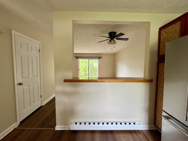 unfurnished room featuring a baseboard radiator, wood finished floors, a ceiling fan, baseboards, and a textured ceiling
