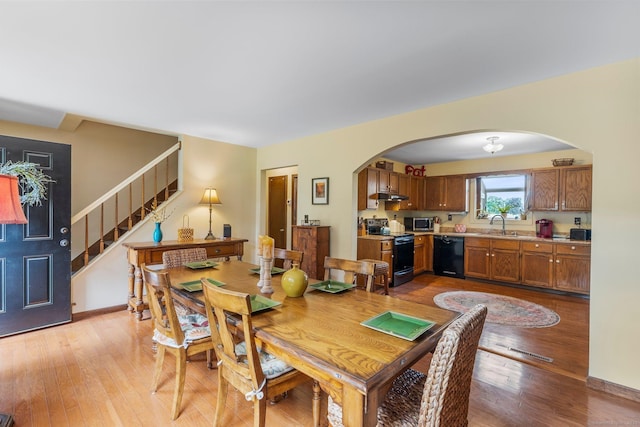 19 Edgewood St, Cromwell, CT 06416 - dining space with arched walkways, light wood finished floors, and stairway