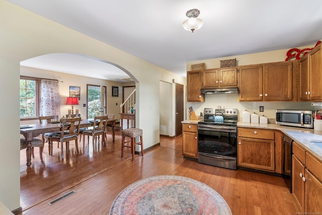 19 Edgewood St, Cromwell, CT 06416 - kitchen featuring appliances with stainless steel finishes, arched walkways, brown cabinets, and light countertops