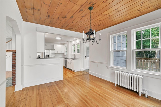 61 Reed St, Stratford, CT 06614 - kitchen featuring radiator heating unit, stainless steel appliances, a chandelier, light wood finished floors, and white cabinetry