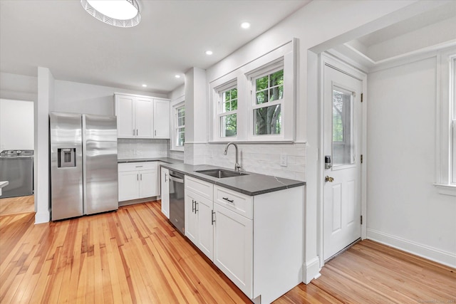 61 Reed St, Stratford, CT 06614 - kitchen featuring stainless steel appliances, a sink, dark countertops, light wood-type flooring, and backsplash