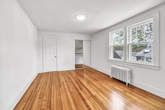 61 Reed St, Stratford, CT 06614 - unfurnished bedroom with radiator heating unit, light wood finished floors, a closet, and baseboards