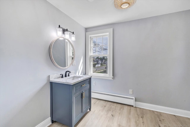 61 Reed St, Stratford, CT 06614 - bathroom featuring baseboard heating, wood finished floors, baseboards, and vanity
