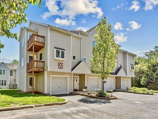 158 Paddock Ave Apt 2001, Meriden, CT 06450 - view of property with an attached garage, a balcony, driveway, and a front yard