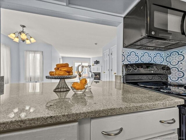158 Paddock Ave Apt 2001, Meriden, CT 06450 - kitchen featuring black microwave, electric stove, plenty of natural light, and a chandelier