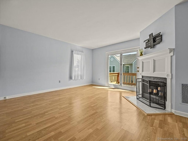 158 Paddock Ave Apt 2001, Meriden, CT 06450 - unfurnished living room with light wood-type flooring, a multi sided fireplace, and baseboards