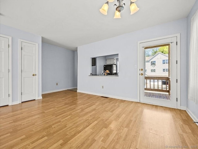 158 Paddock Ave Apt 2001, Meriden, CT 06450 - unfurnished living room featuring light wood-style flooring, baseboards, and a chandelier