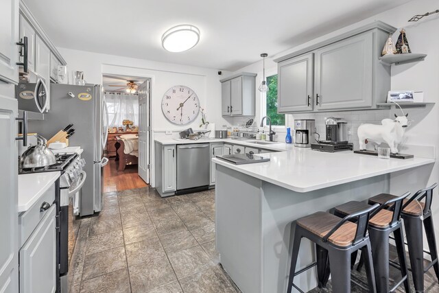 26 Longfellow Ave, Fairfield, CT 06825 - kitchen featuring stainless steel appliances, a peninsula, gray cabinets, a sink, and open shelves
