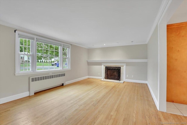 184 Goodale Dr, Newington, CT 06111 - unfurnished living room with radiator, light wood finished floors, ornamental molding, a fireplace with raised hearth, and baseboards