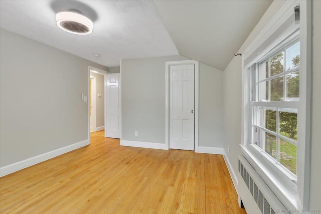 184 Goodale Dr, Newington, CT 06111 - spare room with radiator heating unit, light wood-style flooring, vaulted ceiling, plenty of natural light, and baseboards