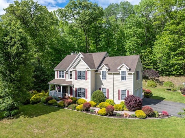 12 Everwood Dr, New Milford, CT 06776 - colonial-style house featuring covered porch, asphalt driveway, a chimney, a front lawn, and an attached garage