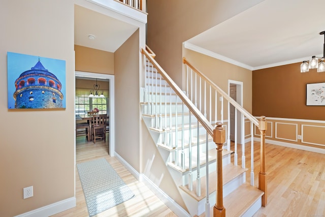 12 Everwood Dr, New Milford, CT 06776 - staircase featuring a chandelier, wood finished floors, ornamental molding, and a decorative wall