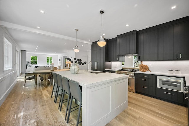 171 Compo Rd S, Westport, CT 06880 - kitchen with high end range, a sink, light wood finished floors, a breakfast bar area, and recessed lighting