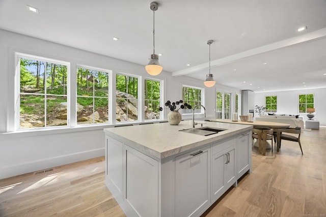 171 Compo Rd S, Westport, CT 06880 - kitchen with a sink, healthy amount of natural light, light wood-style floors, a kitchen island with sink, and beamed ceiling