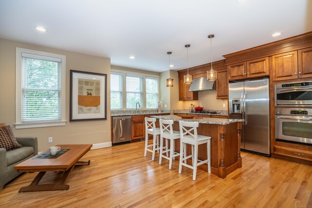 645 Prospect Ave Unit 9, West Hartford, CT 06105 - kitchen with stainless steel appliances, range hood, brown cabinets, healthy amount of natural light, and recessed lighting