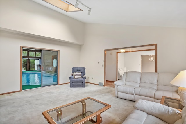 223 Sterling Rd, Trumbull, CT 06611 - carpeted living room with lofted ceiling, rail lighting, baseboards, and a chandelier