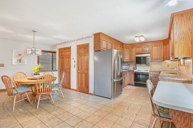 223 Sterling Rd, Trumbull, CT 06611 - kitchen with stainless steel appliances, tasteful backsplash, a chandelier, a sink, and decorative light fixtures