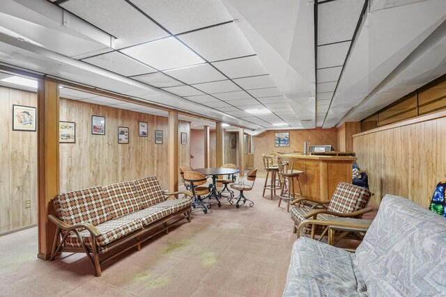 223 Sterling Rd, Trumbull, CT 06611 - living room featuring wooden walls, bar, light carpet, and a paneled ceiling