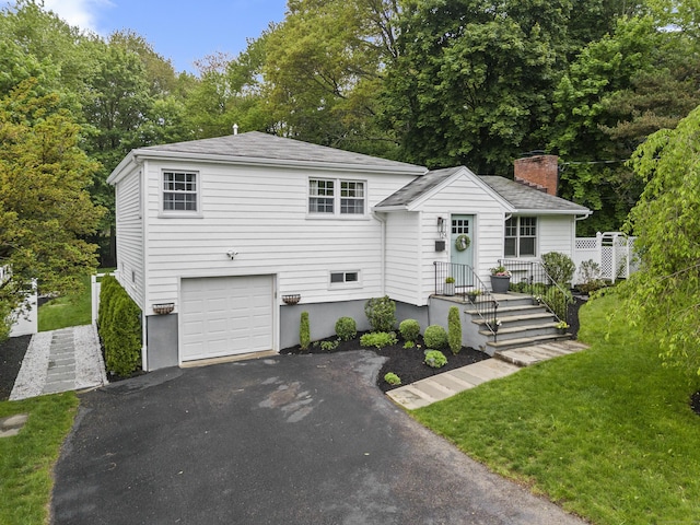 124 Killian Ave, Trumbull, CT 06611 - view of front of house featuring driveway, a garage, a front lawn, and a chimney