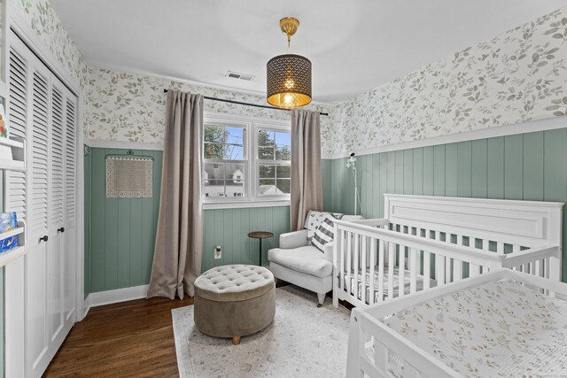 124 Killian Ave, Trumbull, CT 06611 - bedroom with wallpapered walls, wainscoting, wood finished floors, a closet, and a nursery area