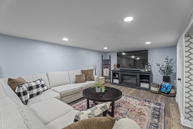 124 Killian Ave, Trumbull, CT 06611 - living room featuring wood finished floors, a glass covered fireplace, recessed lighting, and a decorative wall