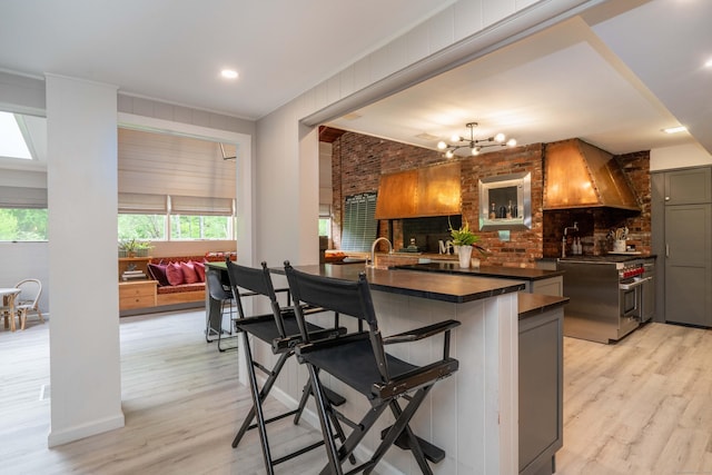 31 Westcliff Dr, West Hartford, CT 06117 - kitchen featuring dark countertops, high end range, light wood-style flooring, a breakfast bar, and recessed lighting