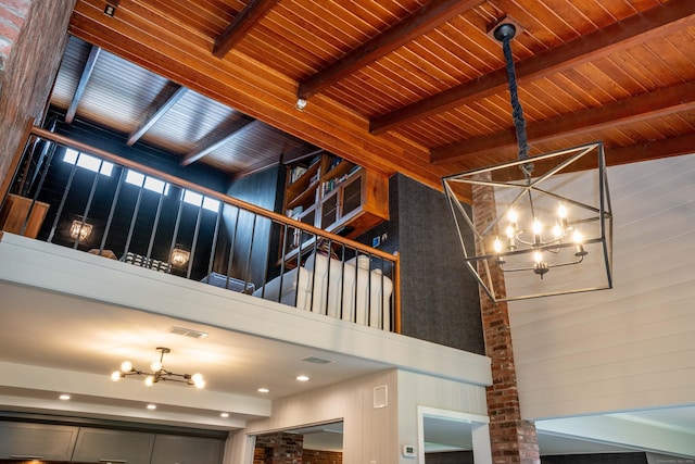 31 Westcliff Dr, West Hartford, CT 06117 - staircase featuring a chandelier, a towering ceiling, beamed ceiling, wooden ceiling, and wood walls