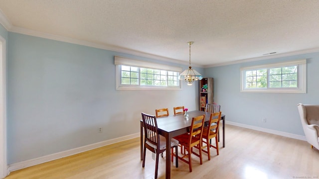 500 Prospect St Apt 4B, New Haven, CT 06511 - dining room featuring light wood-style flooring, crown molding, a chandelier, a textured ceiling, and baseboards