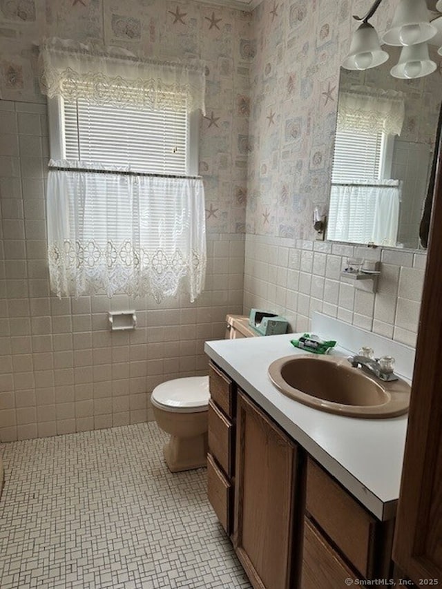 109 Central Ave, Wolcott, CT 06716 - bathroom with tile walls, healthy amount of natural light, wallpapered walls, vanity, and toilet