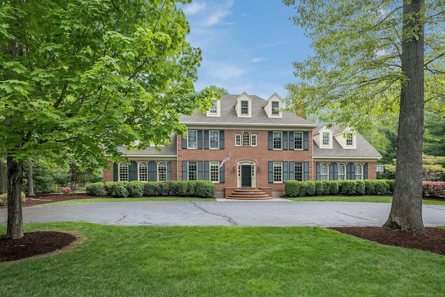 188 Bartlett Dr, Madison, CT 06443 - colonial-style house featuring brick siding, curved driveway, and a front lawn