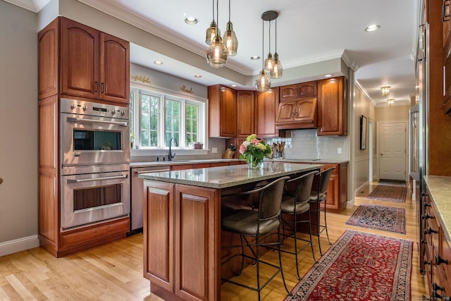 188 Bartlett Dr, Madison, CT 06443 - kitchen with appliances with stainless steel finishes, ornamental molding, a sink, a kitchen breakfast bar, and a center island