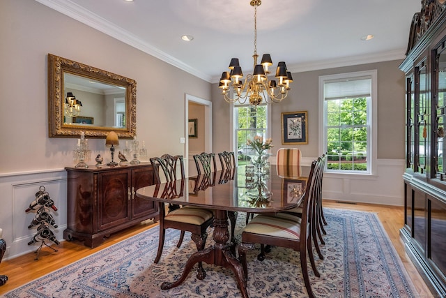 188 Bartlett Dr, Madison, CT 06443 - dining room featuring light wood finished floors, a chandelier, wainscoting, crown molding, and a decorative wall