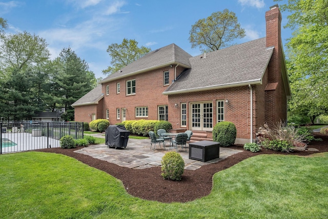 188 Bartlett Dr, Madison, CT 06443 - back of house with french doors, a patio area, a shingled roof, brick siding, and a chimney
