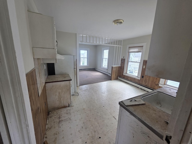 42 Spring St, New London, CT 06320 - kitchen featuring baseboard heating, wainscoting, a sink, healthy amount of natural light, and light floors