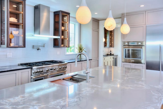22 Apple Tree Trl, Westport, CT 06880 - kitchen featuring stainless steel countertops, high quality appliances, wall chimney range hood, tasteful backsplash, and glass insert cabinets