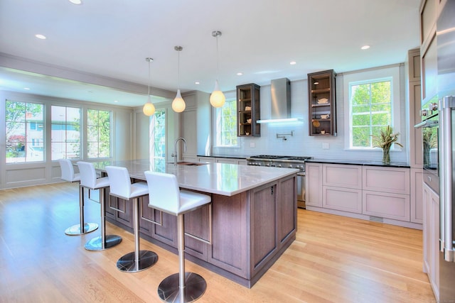 22 Apple Tree Trl, Westport, CT 06880 - kitchen with wall chimney range hood, high end stainless steel range, light wood finished floors, a large island, and decorative backsplash