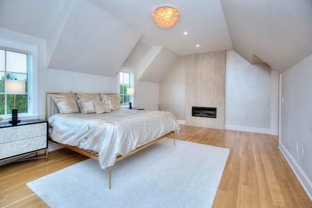22 Apple Tree Trl, Westport, CT 06880 - bedroom with light wood-style flooring, vaulted ceiling, and a large fireplace