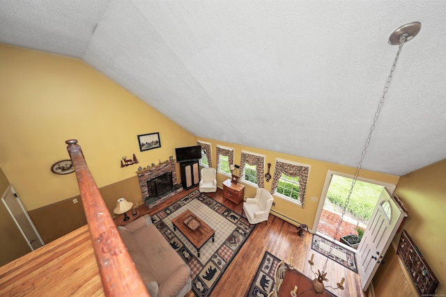 40 Fountainhead Rd, Plymouth, CT 06786 - living room featuring vaulted ceiling, a textured ceiling, wood finished floors, and a brick fireplace
