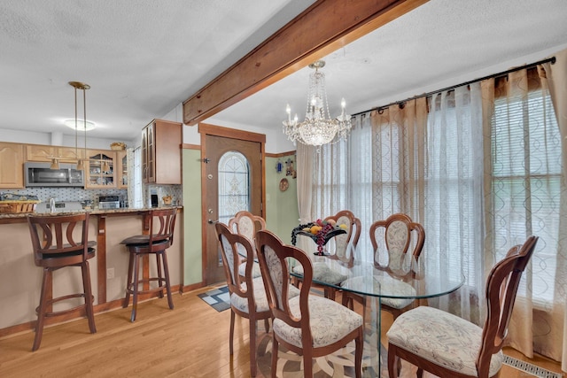 41 Farm Dr Unit 41, Farmington, CT 06032 - dining area featuring light wood finished floors, a chandelier, a textured ceiling, baseboards, and beamed ceiling