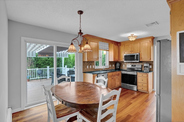136 Windmill Hl, Wethersfield, CT 06109 - kitchen with stainless steel appliances, a baseboard heating unit, light wood finished floors, a sink, and dark countertops