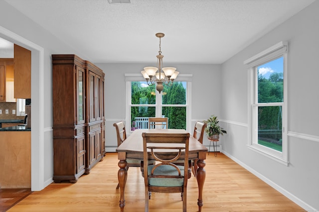136 Windmill Hl, Wethersfield, CT 06109 - dining area with a baseboard radiator, a chandelier, light wood-style flooring, and healthy amount of natural light