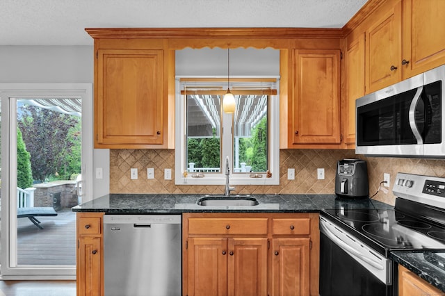 136 Windmill Hl, Wethersfield, CT 06109 - kitchen with appliances with stainless steel finishes, a sink, brown cabinetry, decorative backsplash, and a textured ceiling