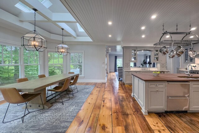 67 Peaceable St, Ridgefield, CT 06877 - kitchen featuring a sink, dark wood-style flooring, glass insert cabinets, baseboards, and a skylight