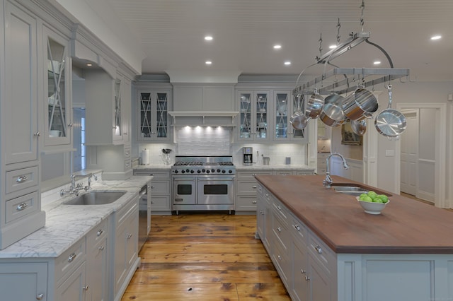 67 Peaceable St, Ridgefield, CT 06877 - kitchen featuring stainless steel appliances, wood counters, a sink, recessed lighting, and a kitchen island with sink